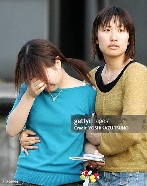 Relatives of a train crash victim leave a gymnasium used as a temporary morgue after they checked the body in Amagasaki, near Osaka, western Japan,...