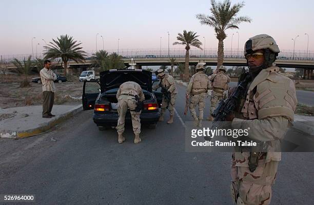 Soldiers from a New York National Guard unit, the Fighting 69th, stop a suspected vehicle on Route Irish, the highway between Baghdad International...