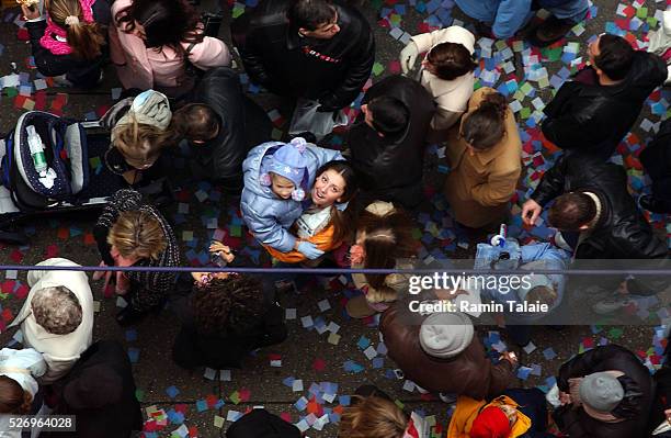 Confetti rains down on Broadway in Times Square as pedestrians look up, December 29 during the annual 'air worthiness test' of the confetti that will...