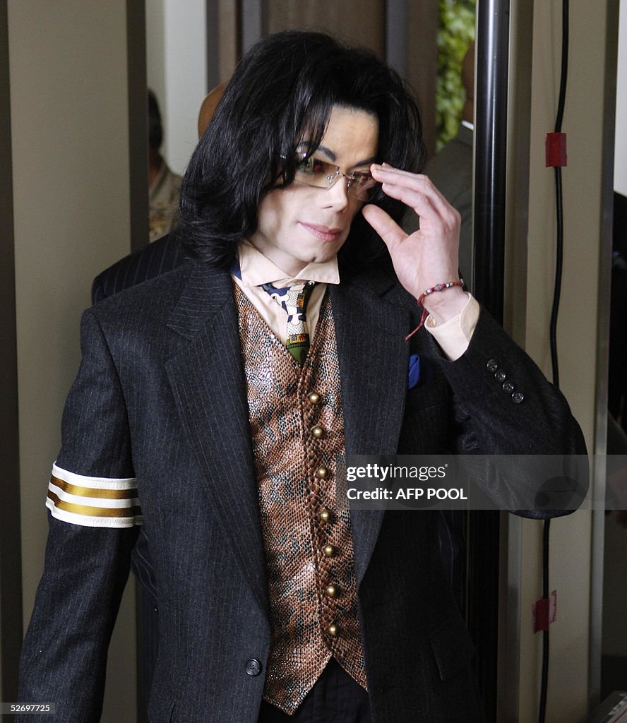 US pop star Michael Jackson removes his
