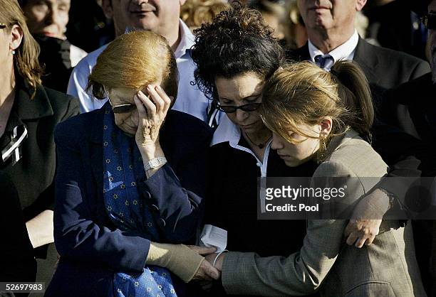 Reuma Weizman , the widow of former Israeli President Ezer Weizman, and his daughter Michal stand with unidentified grieving mourners at the burial...