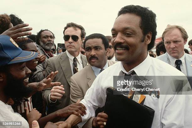 Jesse Jackson, Baptist minister and candidate for the Democratic presidential nomination in 1984, shakes hands with supporters during a campaign stop...