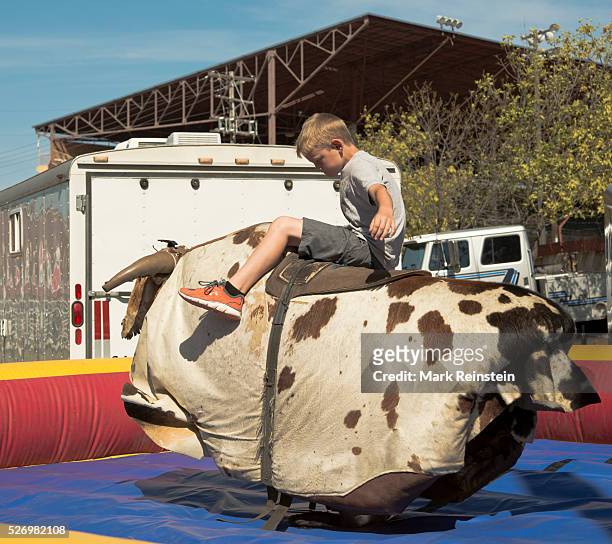 Hutchinson, Kansas 9-13-2015 Young boy shows off his rodeo skills on a mechanical bull today at the State Fair in Hutchinson, Kansas. Credit: Mark...