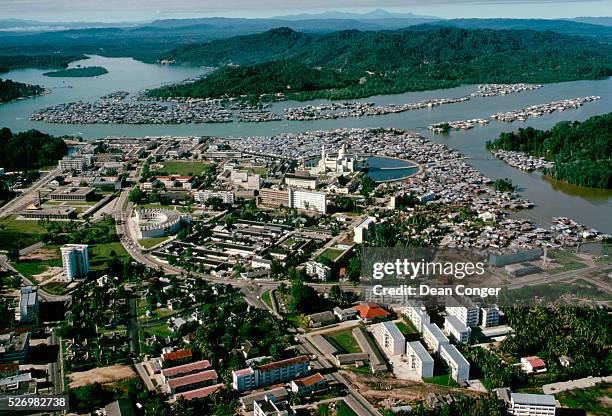 The gold-domed Omar Ali Saifuddin Mosque on the banks of a water village of stilt houses called Kampong Ayer. Brunei.