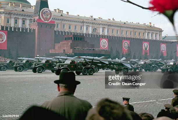 Communist leaders review a convoy of military trucks, loaded with rockets, as it passes in front of the Lenin Memorial during the annual May Day...
