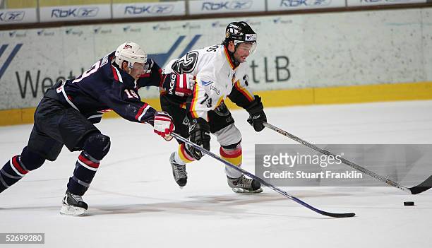 David Legwand of the USA makes a lunges at Tino Boos of Germany during The International Friendly Ice Hockey match between Germany and USA at The...