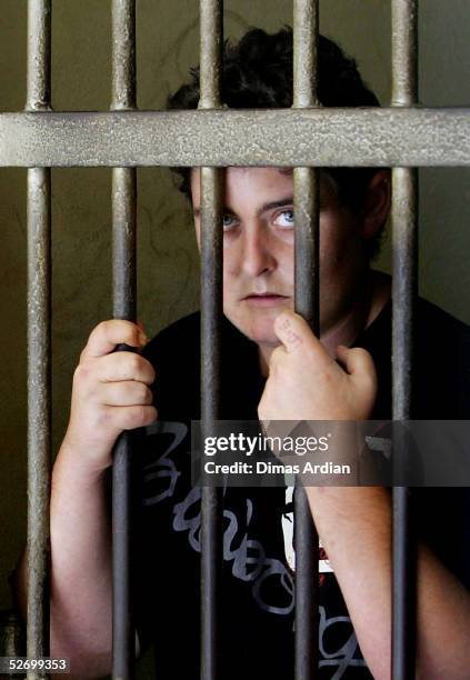 Year-old woman Renae Lawrence of Newcastle, Australia, is seen behind her cell bars, as an Indonesian police officer checks food supply given by...