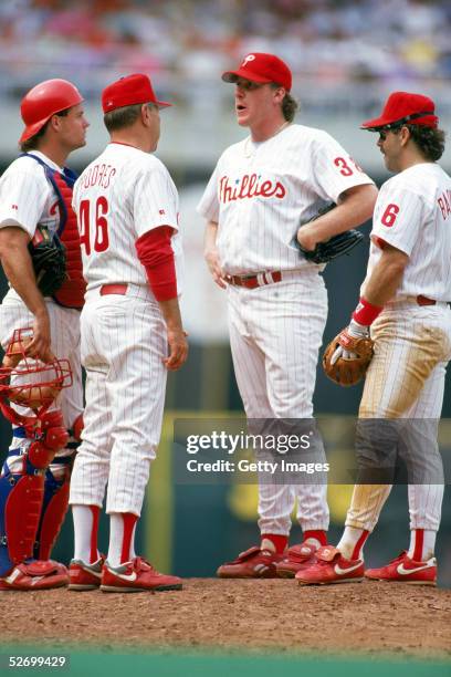 Pitcher Curt Schilling of the Philadelphia Phillies talks on the mound with catcher Darren Daulton, pitching coach Johnny Podres and infielder Wally...