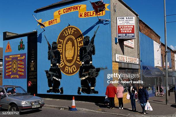 Mural of loyalist soldiers dressed in black and holding machine guns. The peace talks have inspired many such murals in Belfast where unionists tend...