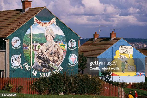 Republican mural on Upper Falls Road in Belfast depicts an Irish soldier, while an adjacent mural declares, "Time for Peace." The Northern Ireland...