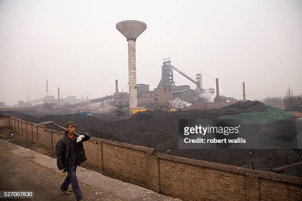 Miner walks past coal used for smelters at a steel mill in Datong, Shanxi Province. China has now overtaken the U.S. As the world's largest emitter...