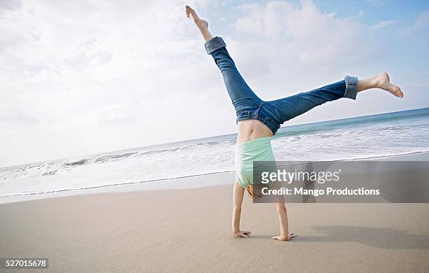 woman cartwheeling on beach - cartwheel stock pictures, royalty-free photos & images