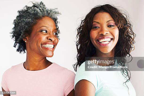 happy mother and daughter - african american young woman portrait white background stock-fotos und bilder