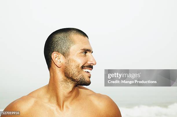 barechested man standing on beach - barba incolta foto e immagini stock