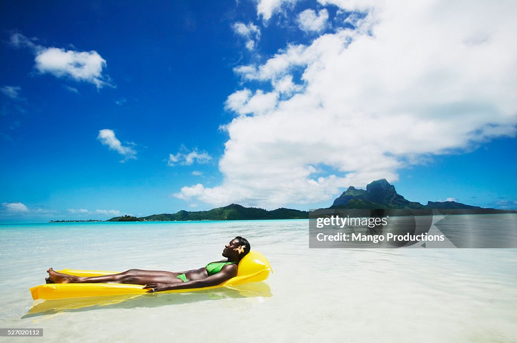 Woman In Inflatable Raft Woman Relaxing On An Inflatable Raft Floating In The Ocean High-Res ...