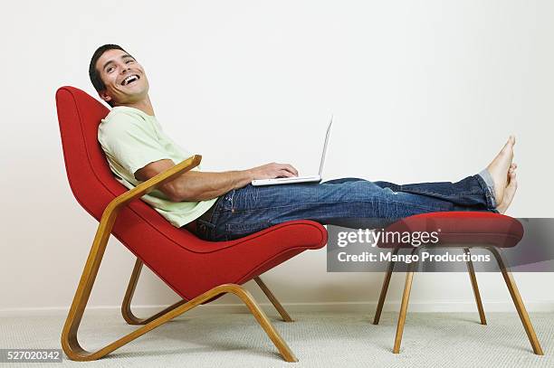 man using laptop in lounge chair - profile laptop sitting stock pictures, royalty-free photos & images