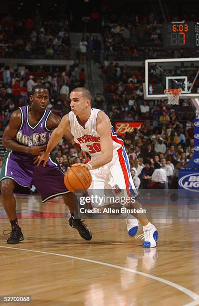 Carlos Arroyo of the Detroit Pistons drives around Anthony Goldwire of the Milwaukee Bucks during the game on April 15, 2005 during their game at the...