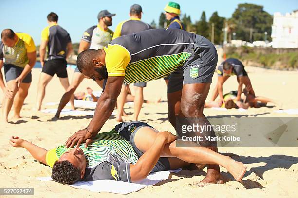 Semi Radradra assists Josh Papalii during stretching at the Australia Kangaroos Test team recovery session at Coogee Beach on May 2, 2016 in Sydney,...