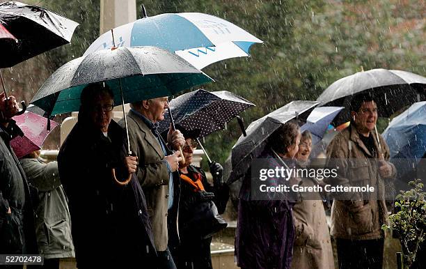 Members of the public are seen in the grounds of The Parish Church of Saint Mary the Virgin during the funeral of actor Sir John Mills takes place...
