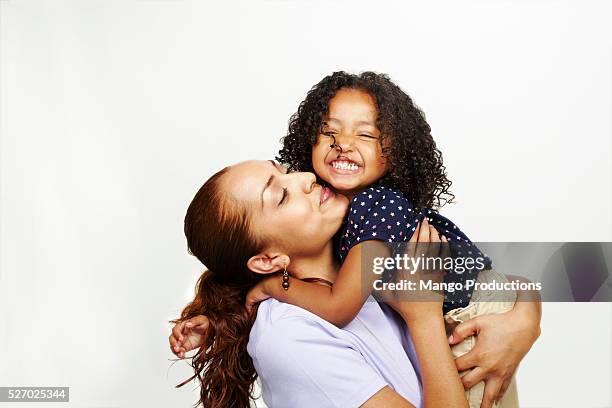 woman and young girl hugging and kissing - family portrait stockfoto's en -beelden