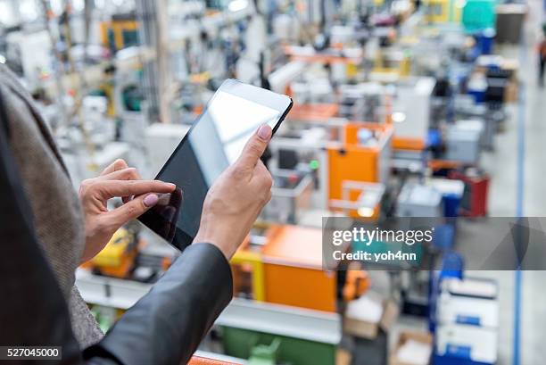 weibliche manager arbeiten mit tablette im fabrik - industrial warehouse stock-fotos und bilder