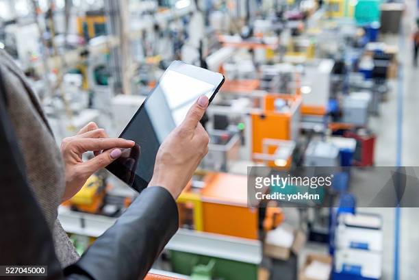 female manager working on tablet in factory - factory stockfoto's en -beelden