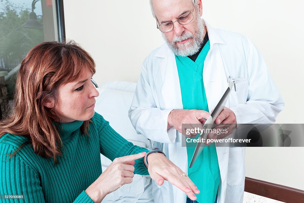 Doctor Showing Patient Smart Device to Monitor Her Health