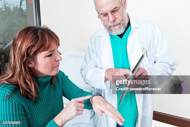 médico mostrando paciente dispositivo inteligente para monitorizar a sua saúde - computador utilizável como acessório imagens e fotografias de stock