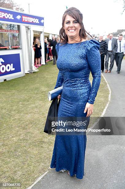 Female horse racing fan pictured wearing a blue full length dress as she attends Ladies Day during The Grand National Meeting at Aintree racecourse...