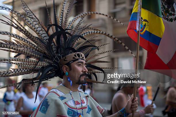 Man in an Aztec dance group dances in a May Day march by the Coalition for Humane Immigrant Rights of Los Angeles on May 1, 2016 in Los Angeles,...