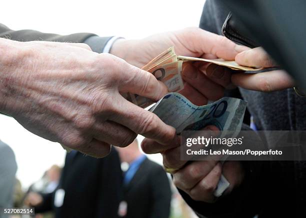 View of an on-course bookmaker paying out to punters after a race during the 2009 Cheltenham National Hunt Festival at Cheltenham racecourse in...