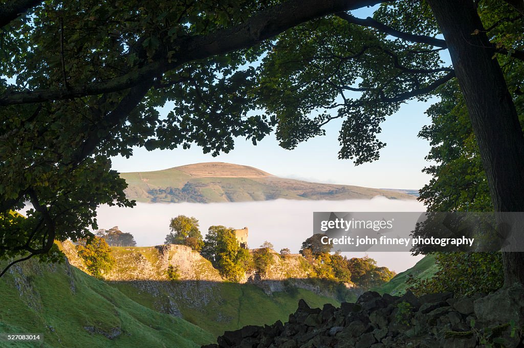 Peveril Castle framed with an oak tree, Autumn sunrise, Castleton, English Peak District. UK. Europe.