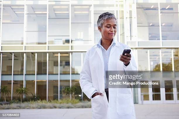 female doctor texting - doctor using phone stock pictures, royalty-free photos & images