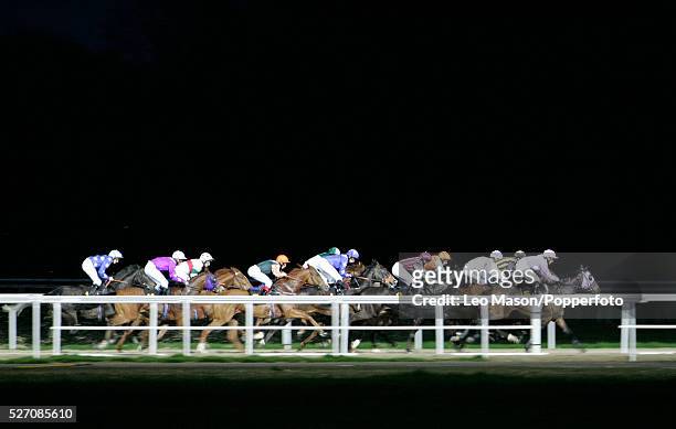 View of horses and riders competing in an evening race meeting in the dark at Kempton Park race course near London on 15th November 2006.