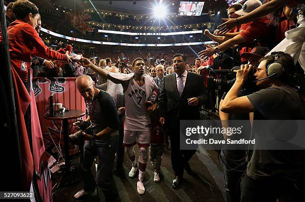 Kyle Lowry of the Toronto Raptors hands his shoe to a fan as he walks off the court after defeating the Indiana Pacers in Game Seven of the Eastern...