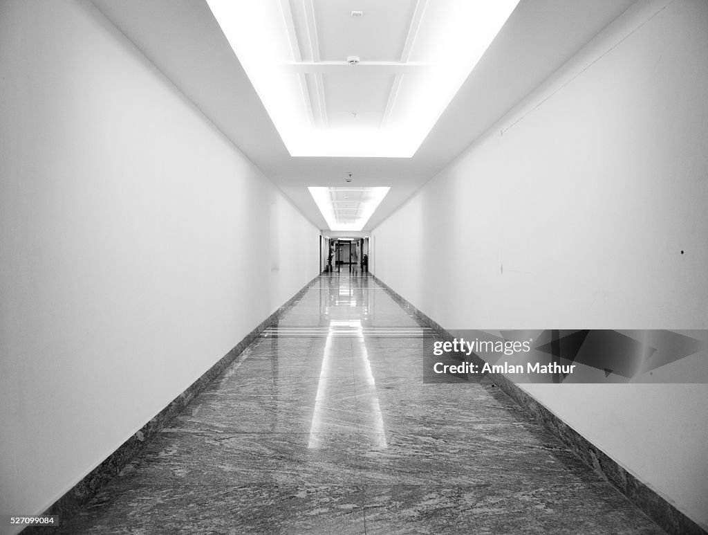 Black and white of a long gloomy corridor