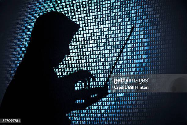 Computer hacker silhouette. Blue binary code background. Seattle office.