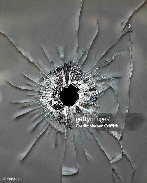 bullet hole in glass - bullet holes stock-fotos und bilder