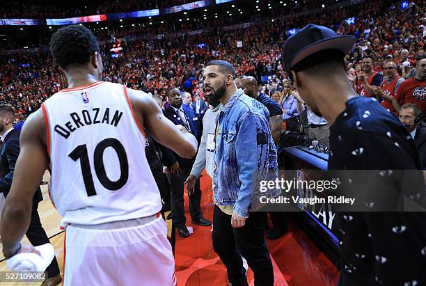 Singer Drake congratulates DeMar DeRozan of the Toronto Raptors following Game Seven of the Eastern Conference Quarterfinals against the Indiana...