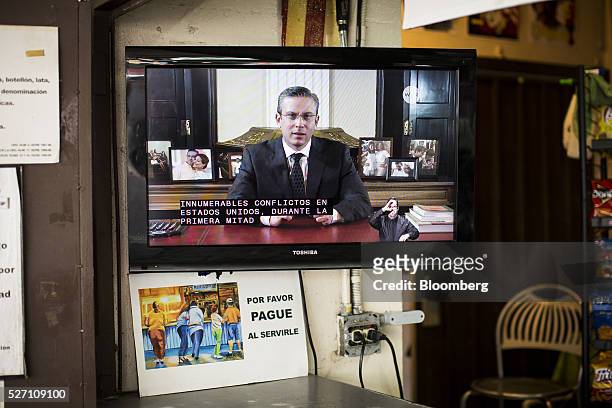 Alejandro Garcia Padilla, governor of Puerto Rico, is seen giving a speech on a television screen in a bar in San Juan, Puerto Rico, on Sunday, May...