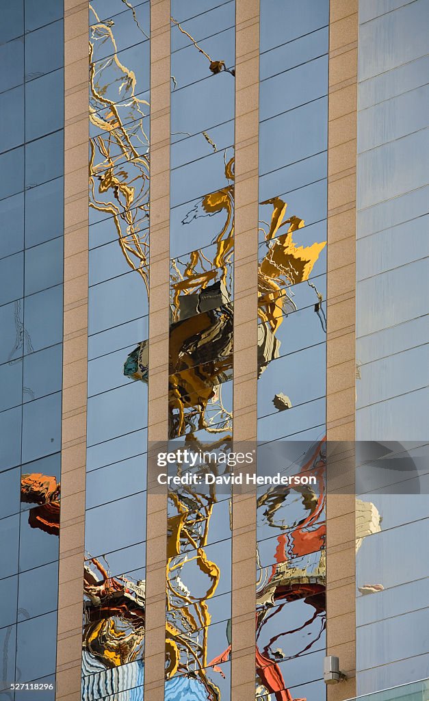 Construction crane reflected in the windows of a skyscraper