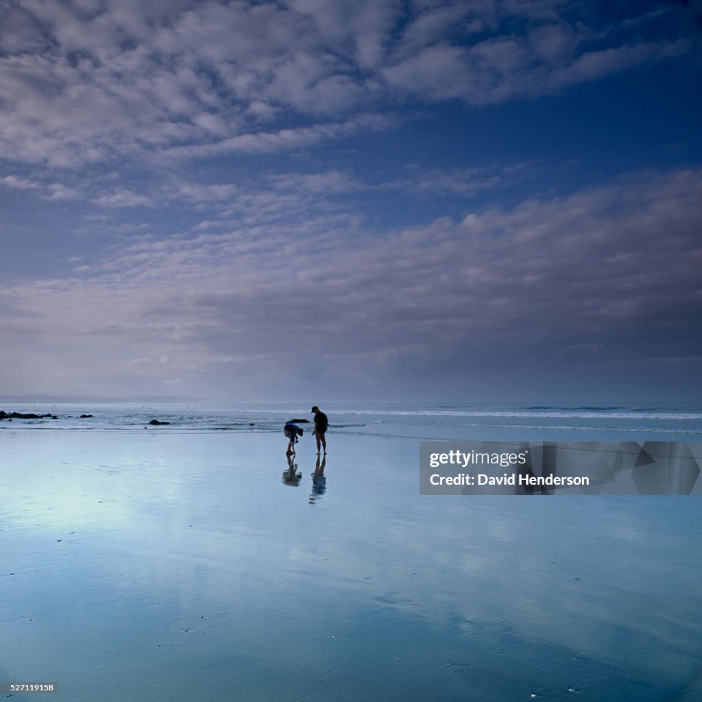 Two people on beach at dusk