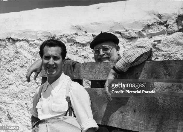 American author Ernest Hemingway leans against a wood fence next to Spanish matador Luis Miguel Dominguin , late 1950s. Dominguin was the subject of...