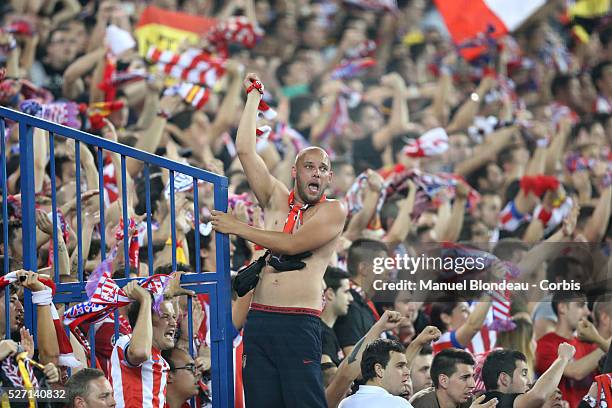 Supporters of Club Atletico de Madrid wave flags and scarves during the UEFA Champions league Quarter Final second leg football match between Club...