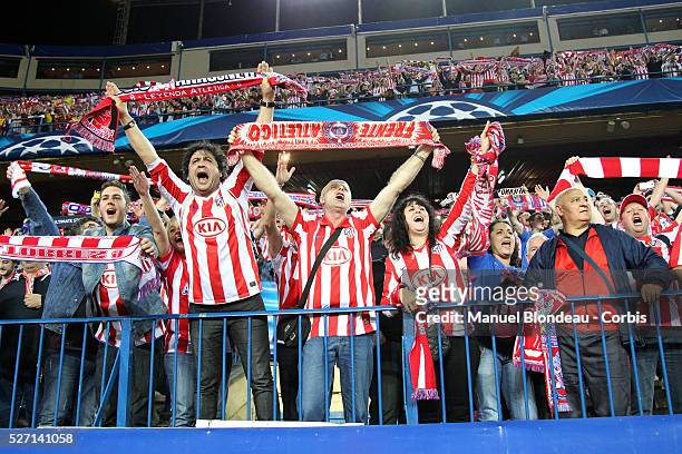 Supporters of Club Atletico de Madrid wave flags and scarves during the UEFA Champions league Quarter Final second leg football match between Club...