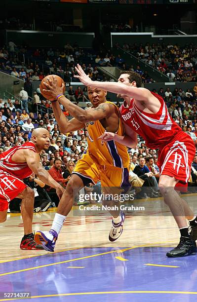 Caron Butler of the Los Angeles Lakers drives against Scott Padgett of the Houston Rockets during the game at Staples Center on April 7, 2005 in Los...