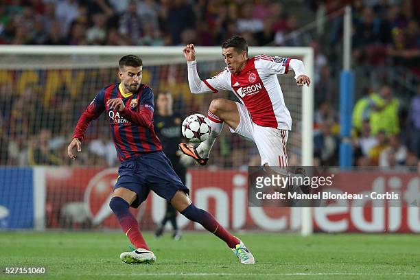 Bojan Krkic of Ajax Amsterdam jumps to control the ball under pressure from Gerard Pique of FC Barcelona during the UEFA Champions league football...