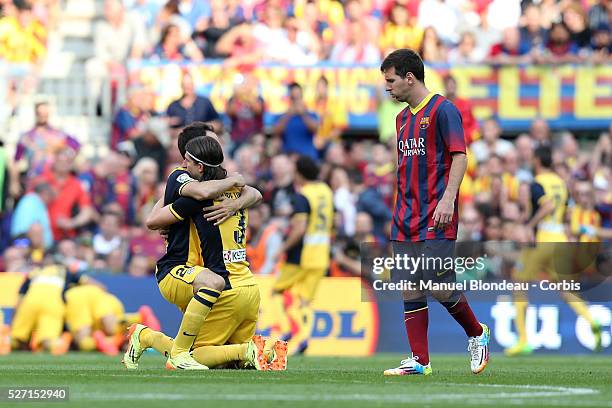 Juanfran and Filipe Luis of Club Atletico de Madrid celebrate as Lionel Messi of FC Barcelona looks dejected during the La Liga football match...