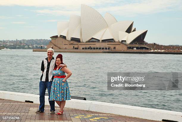 Couple pose for a photograph in front of the Sydney Opera House in Sydney, Australia, on Friday, April 29, 2016. Australias drive to balance the...