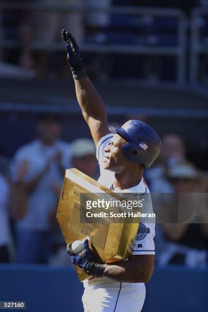 Rickey Henderson of the San Diego Padres holds a gold home plate after hitting a one-run home run in the third inning against the Los Angeles Dodgers...